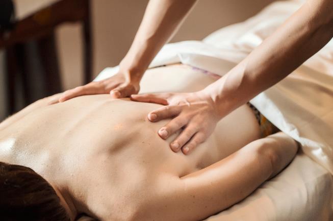 a woman getting a back massage in a spa